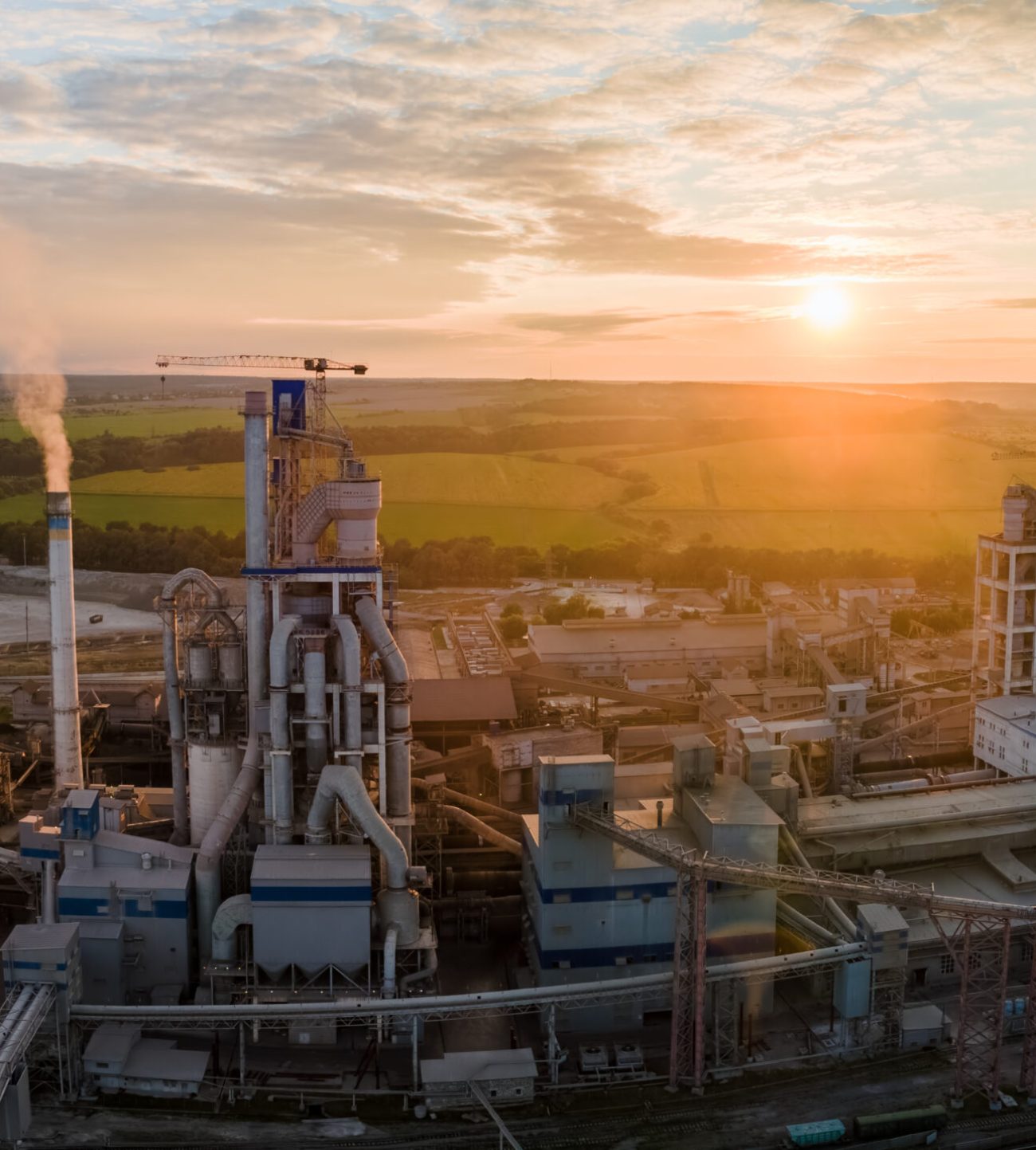 Aerial view of cement factory tower with high concrete plant structure at industrial production area. Manufacturing and global industry concept.